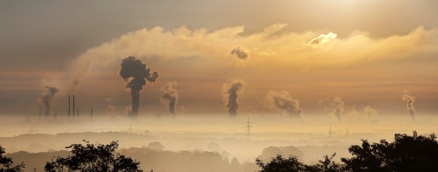 Chimneys emit smoke into the sky